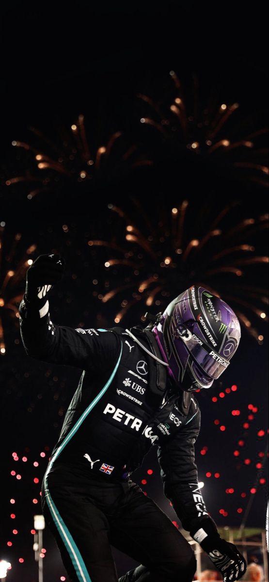 a person wearing a helmet and gloves with fireworks in the background