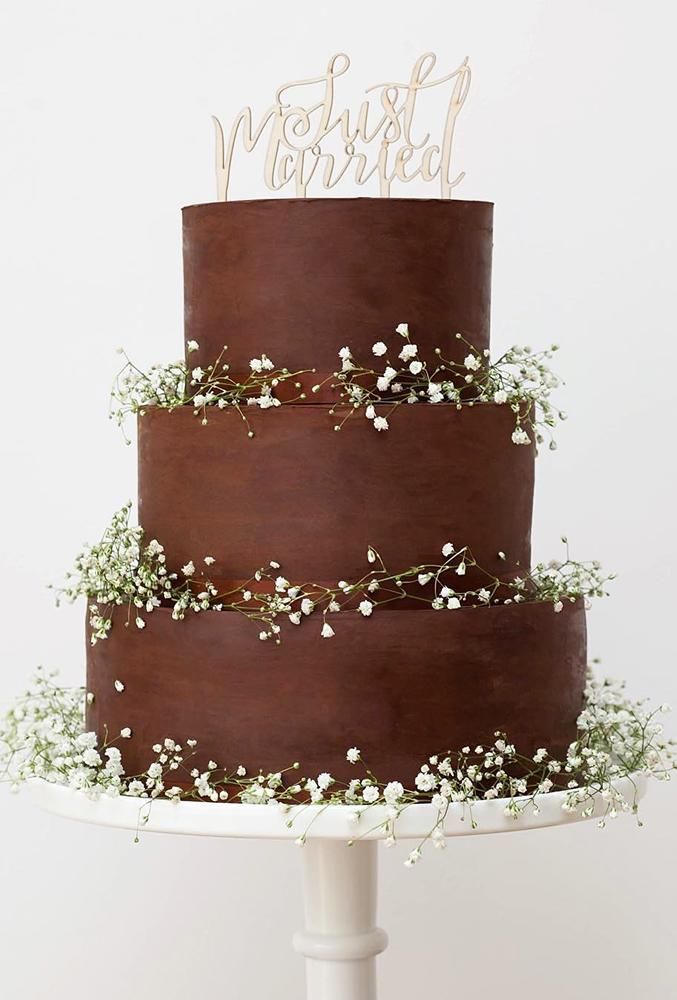 a three layer chocolate cake with baby's breath on top