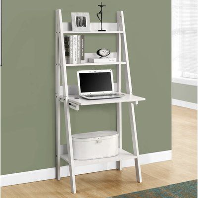 a white computer desk with a laptop on top and shelves above it, against a green wall