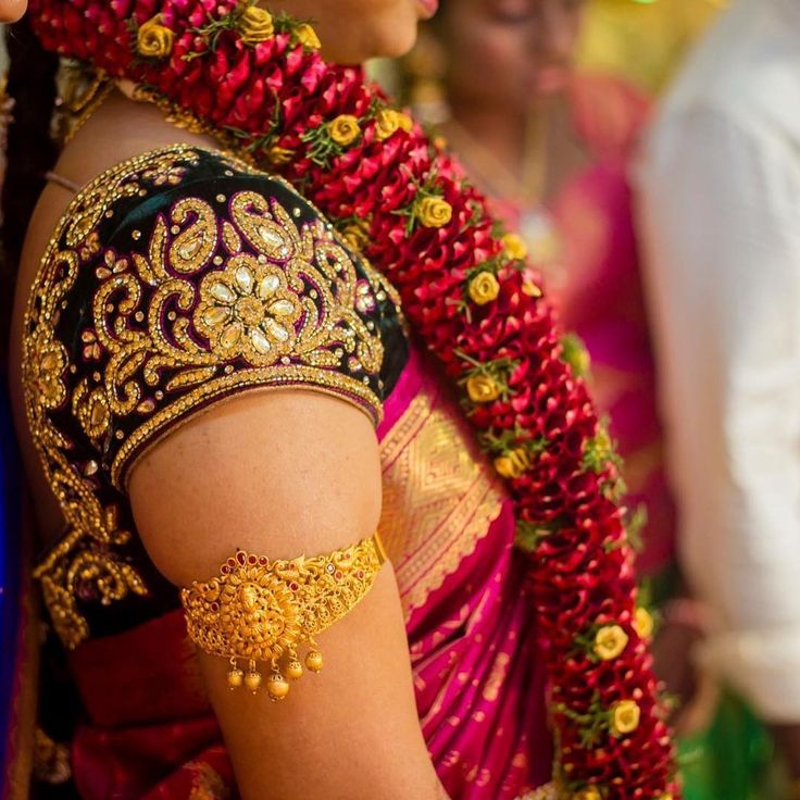 a woman wearing a red and gold sari