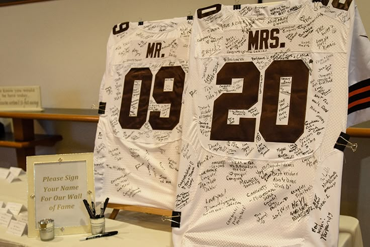 two football jerseys with signed numbers on them sitting on a table next to other items