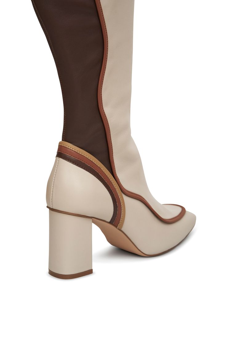 The AJI Teddy Tall Boot is a contemporary take on your neutral brown boots. With fashion-forward design for comfort and flattery. Whether you need a pair of boots for a casual outing or a more formal occasion, the AJI Teddy is your new essential. Made with Brown/Bone soft calf leather, with contrast piping in brown neutrals. A stretch leather shaft. Features a hidden side pocket, padded footbed for all day wear, slightly squared toe, and a side zipper closure with silver metal finish. 3.25" heel Brown Mid-calf Boots With Leather Sole For Fall, Brown Leather Platform Boots For Spring, Trendy Beige Leather Boots, Chic Brown High Ankle Platform Boots, Brown Mid-calf Boots With Round Toe In Calf Leather, Beige Leather Mid-calf Boots High Ankle, Brown Calf Leather Mid-calf Boots With Round Toe, Modern Beige Calf Leather Boots, Chic High Ankle Platform Boots In Brown