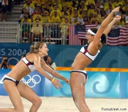 two women in bikinis are playing volleyball