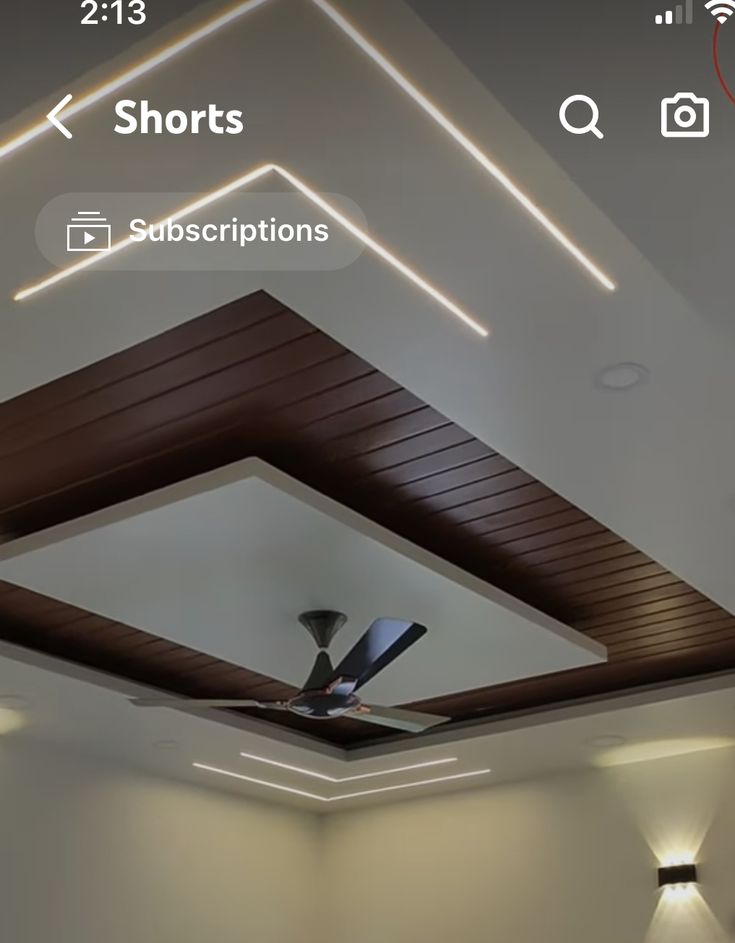 a ceiling fan in the middle of a room with lights on and below it is an appliance