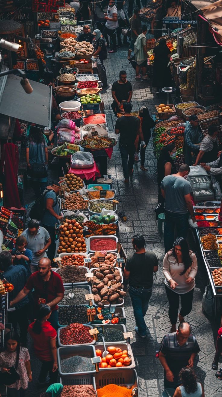 people are walking through an outdoor market with many fruits and veggies on display