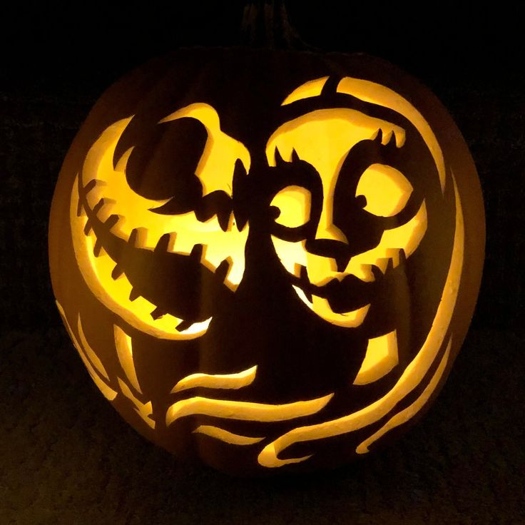 a carved pumpkin with an image of a cat on it's face in the dark