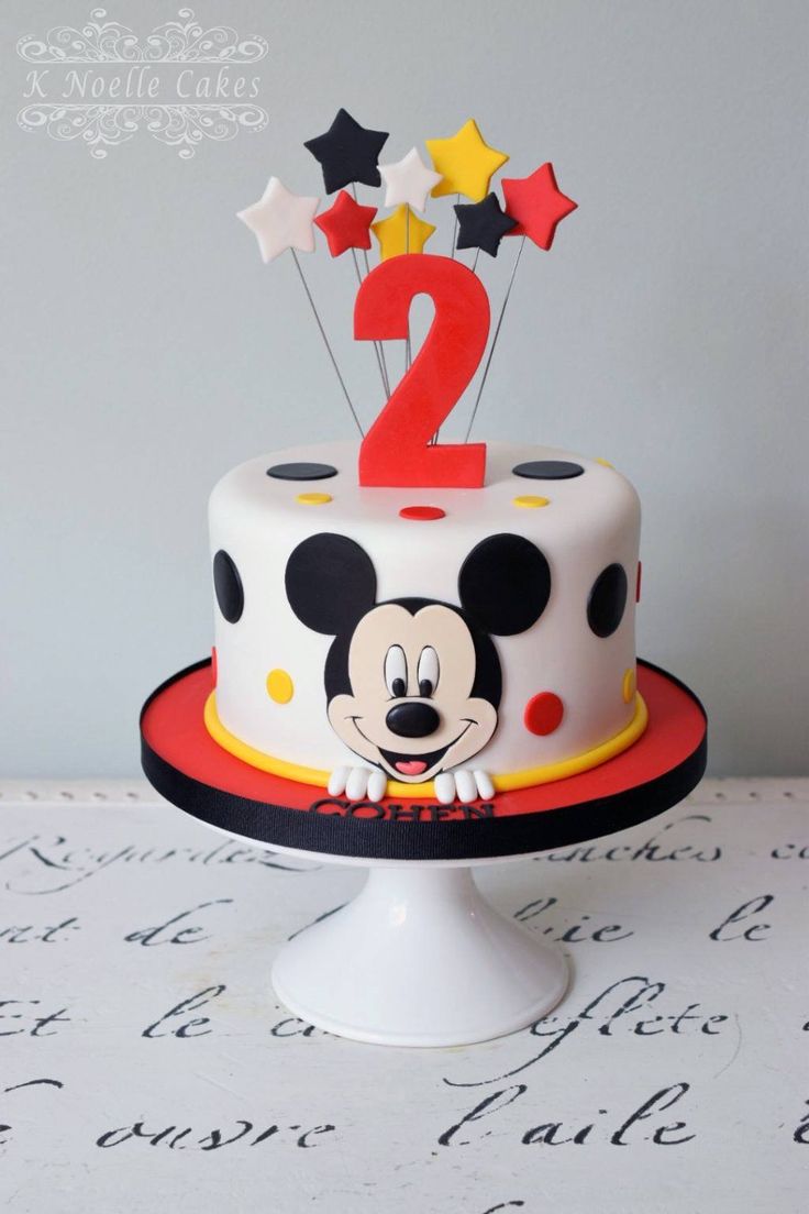 a mickey mouse birthday cake with stars and numbers on the top is ready to be eaten