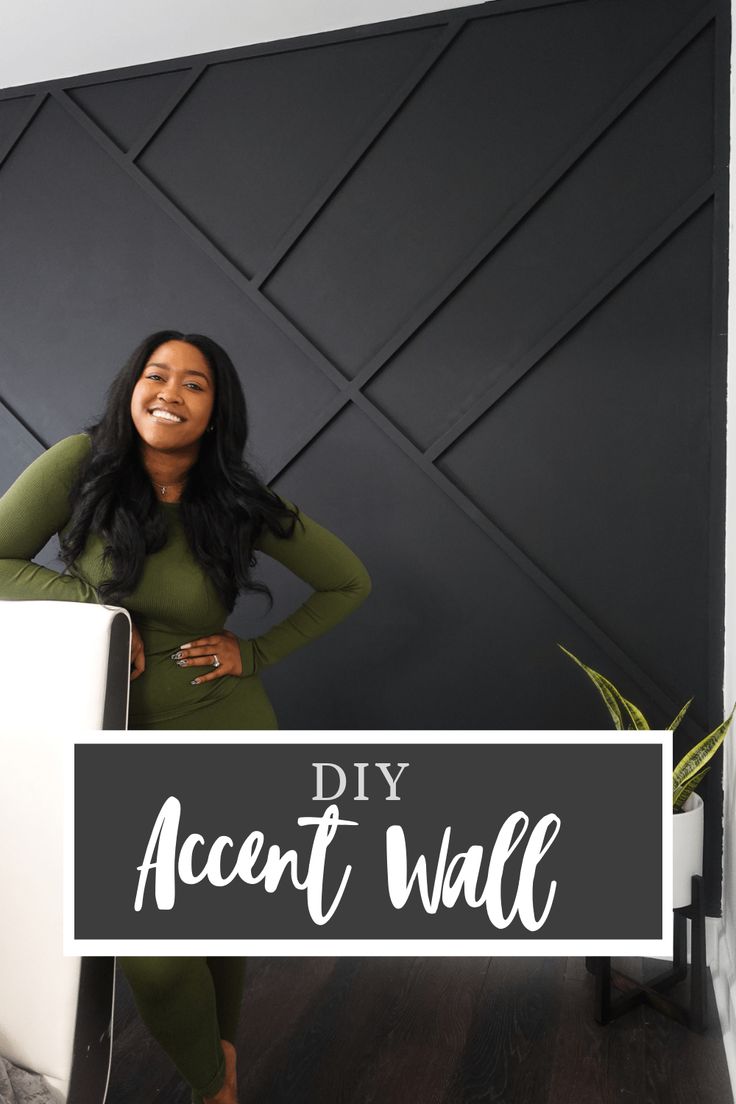 a woman standing in front of a black wall with the words diy accent wall