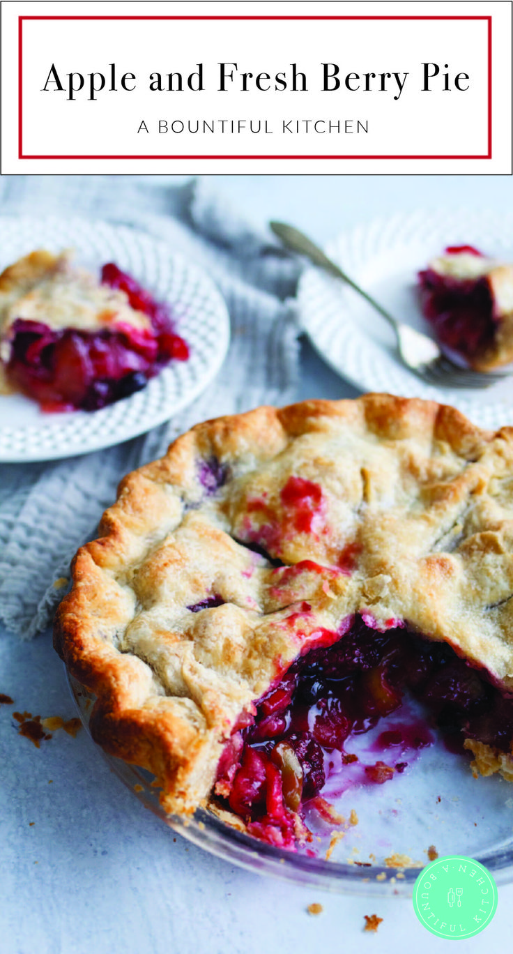 an apple and fresh berry pie on a plate