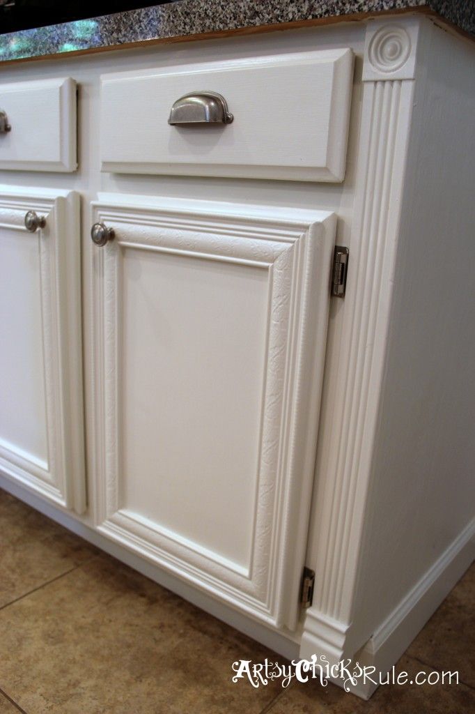 a kitchen with white cabinets and granite counter tops in the middle of the flooring