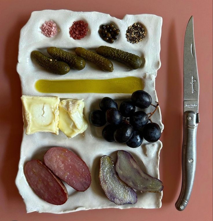 an assortment of different types of food on a plate with a knife next to it