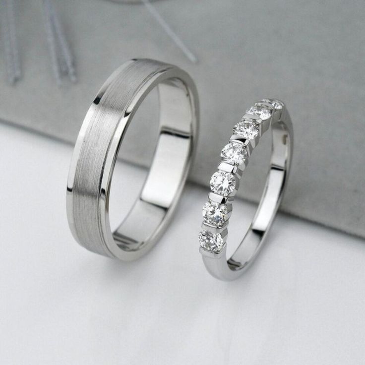 two wedding rings sitting next to each other