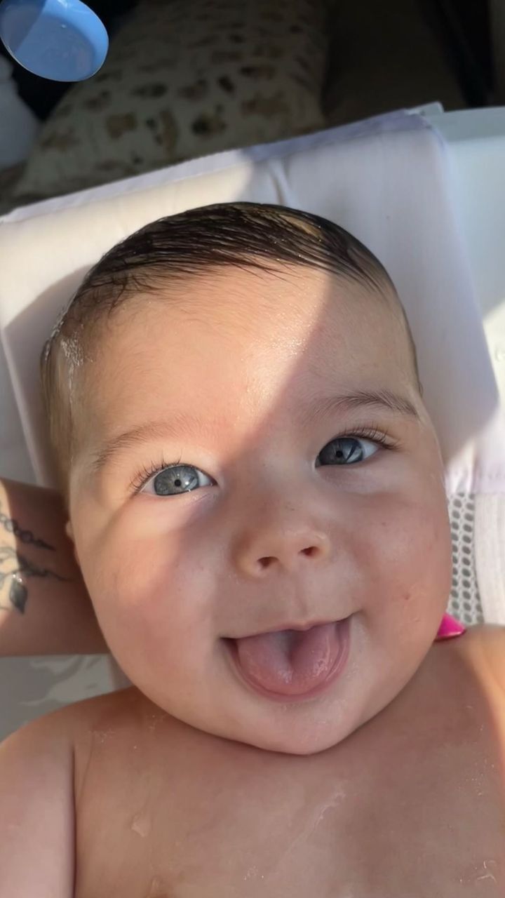 a close up of a baby laying in a bath tub