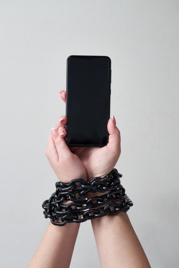 a person holding up a cell phone with chains around their wrists and armbands