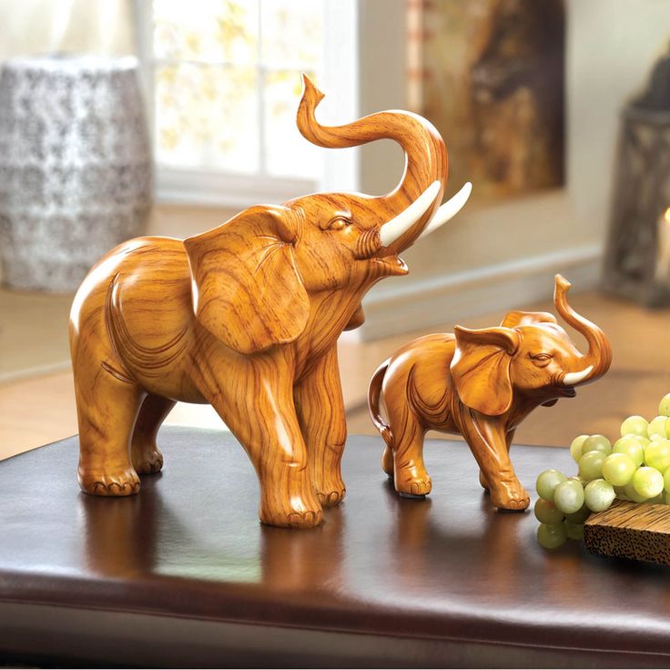 three wooden elephants standing on top of a table