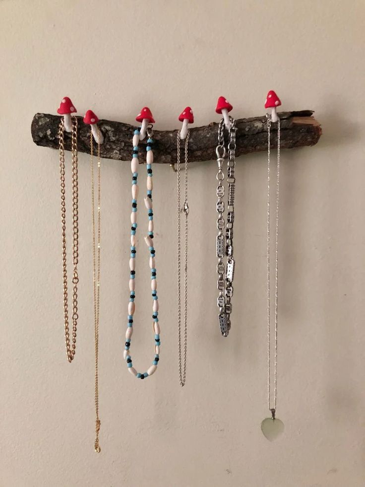 several necklaces are hanging on a wooden branch