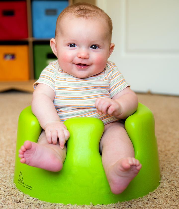 a baby sitting on top of a green potty in the middle of a room