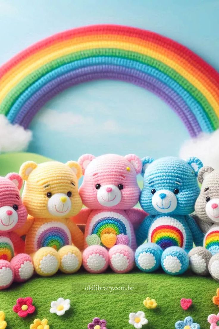 several crocheted teddy bears are sitting in front of a rainbow and flower field