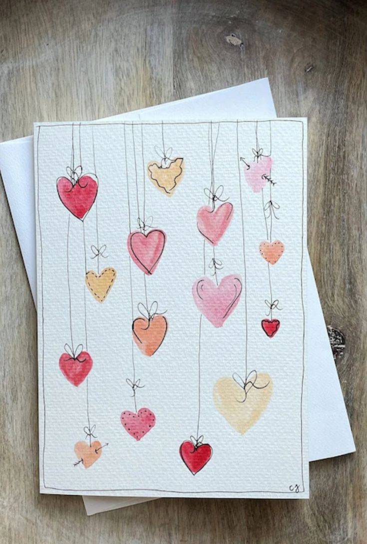 two cards with hearts hanging from strings