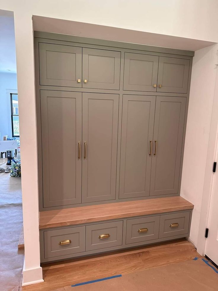 an empty room with gray cabinets and drawers