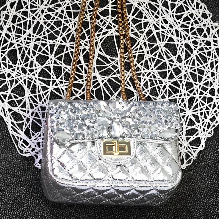 Get ready to slay any outfit with the Erica Fragrance Clutch Bag! Sparkling rhinestones, timeless design, and impeccable craftsmanship make this bag a conversation starter wherever you are. Its high-quality materials make it durable, and its luxurious design makes it the centre of attention. Make a statement with this phenomenal clutch bag! Exclusively available in silver. Luxury Pouch Bags As Fashion Accessory, Luxury Handheld Bag With Chain Strap, Luxury Bags With Rhinestones, Luxury Clutch Shoulder Bag Fashion Accessory, Luxury Clutch Shoulder Bag, Luxury Rhinestone Shoulder Bag With Top Handle, Luxury Shoulder Bag With Rhinestones And Top Handle, Chic Silver Bags With Rhinestones, Luxury Silver Bag With Chain Strap