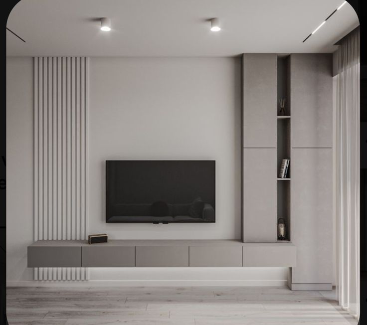 an empty living room with a flat screen tv on the wall and bookshelves