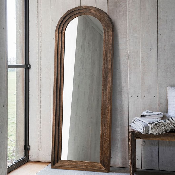 a large mirror sitting on top of a wooden floor