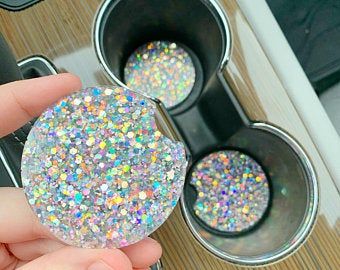 a person is holding a glitter ball in front of some muffin tins on a table