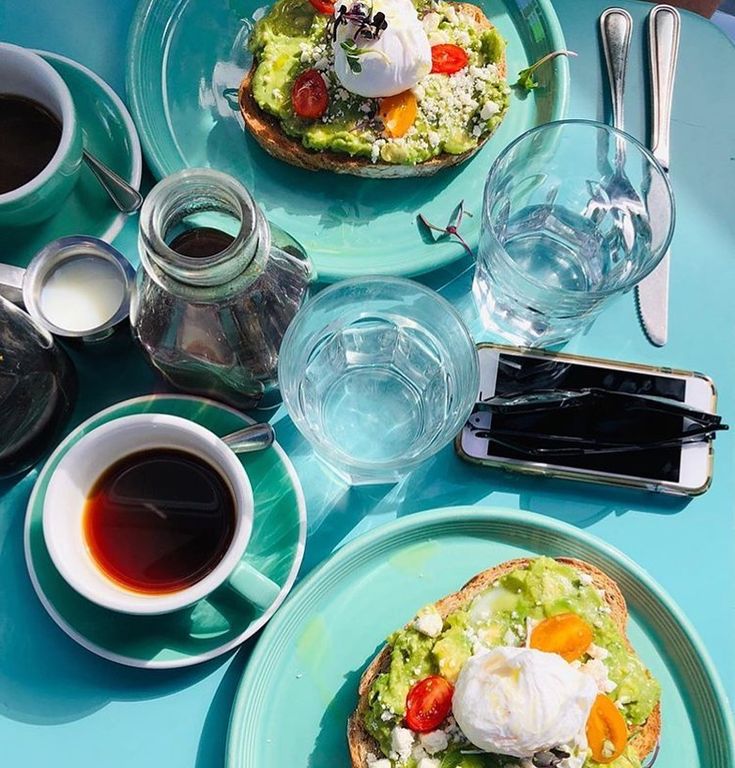 two plates with food on them next to cups and saucers