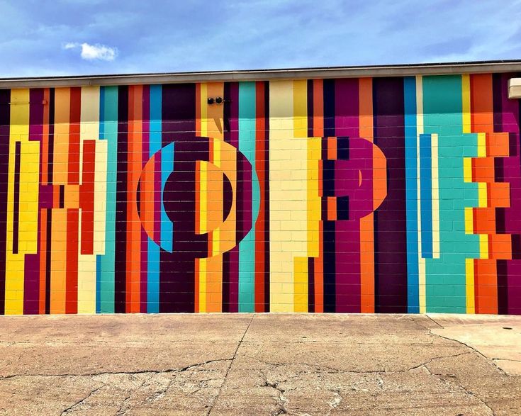 a large colorful wall painted on the side of a building with letters and numbers in different colors