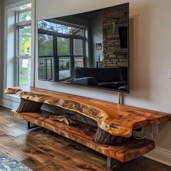 a large wooden bench sitting in front of a tv mounted on a wall next to a window