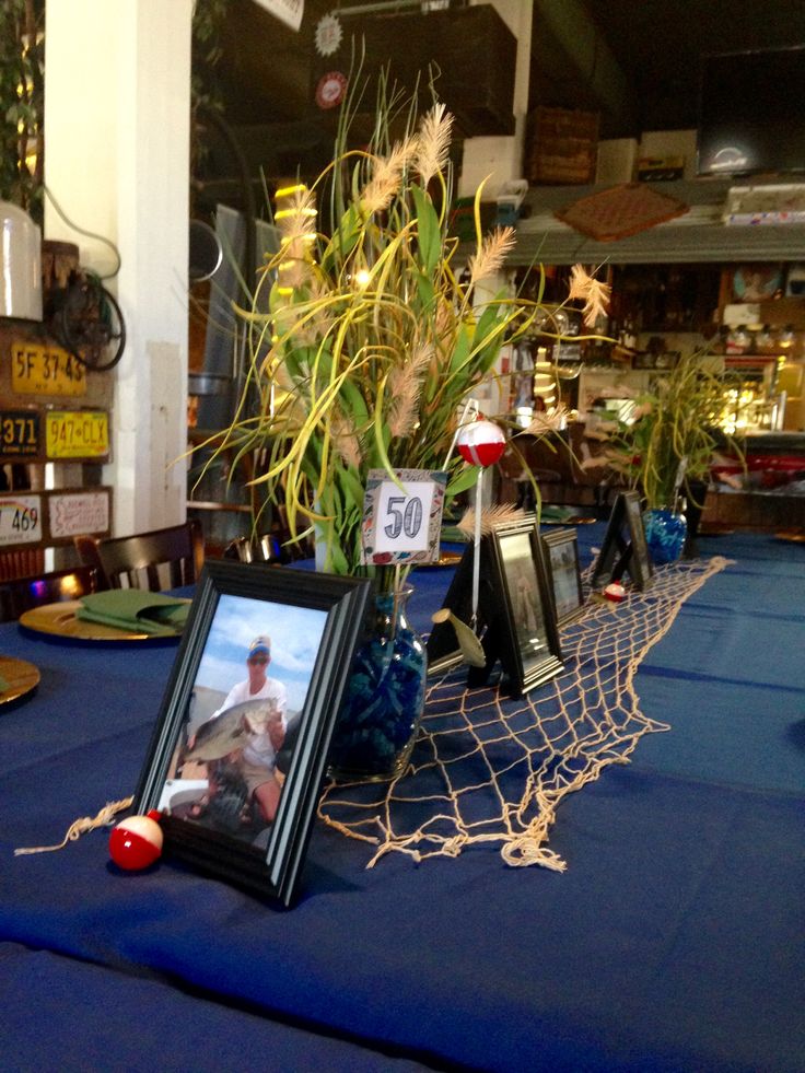 a table topped with pictures and flowers on top of a blue cloth covered tablecloth