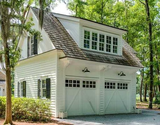 a white house with two garages in the driveway