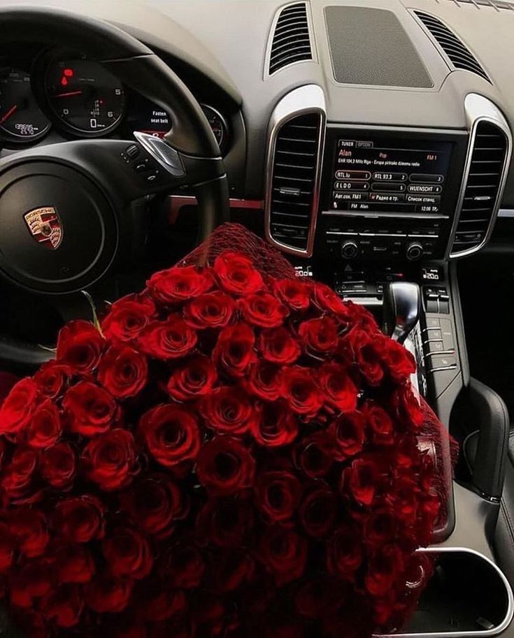 a bunch of roses sitting in the center of a car's steering wheel and dashboard