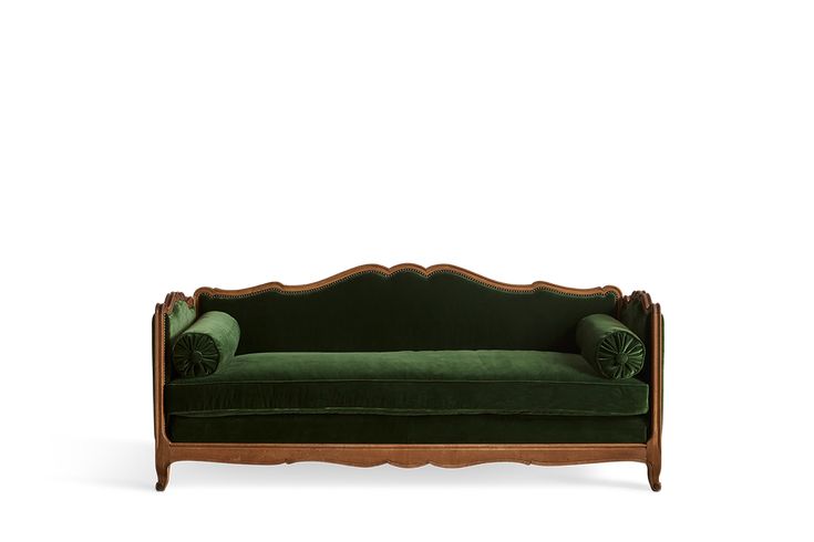 a green couch sitting on top of a wooden frame