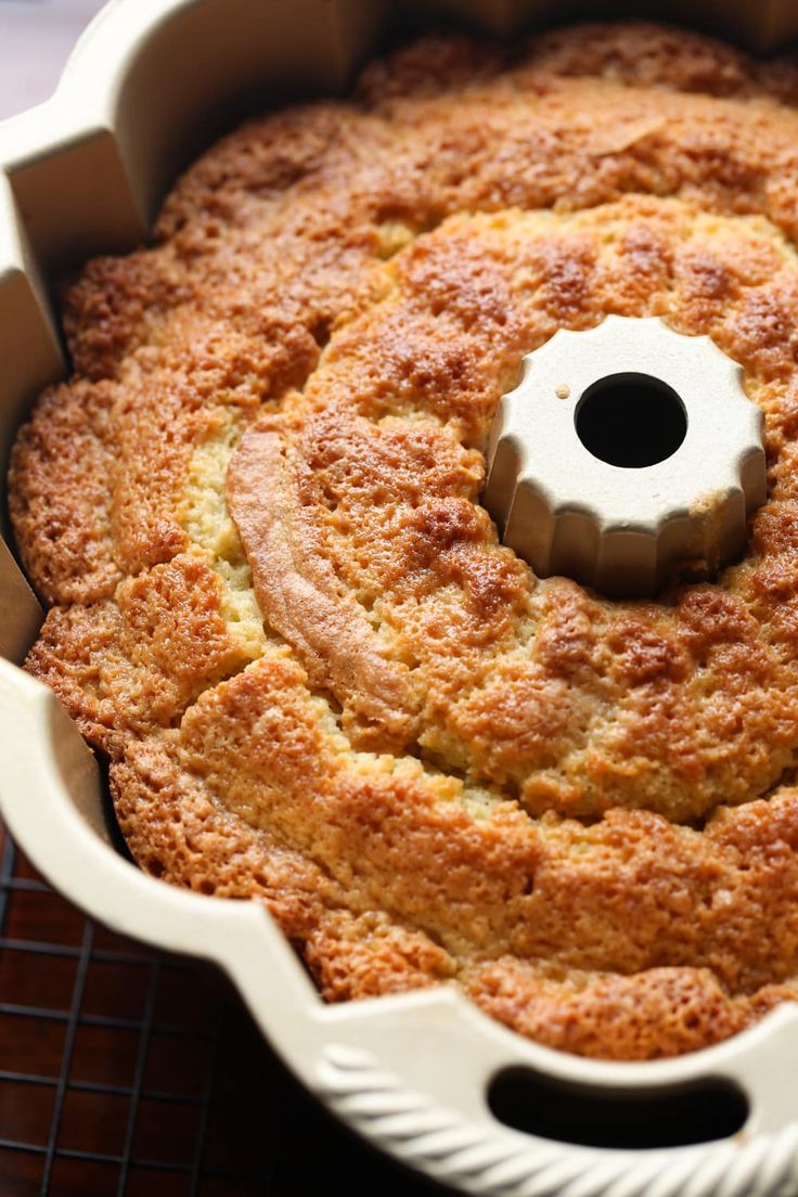 a bundt cake in a white pan on a cooling rack with a hole in the middle