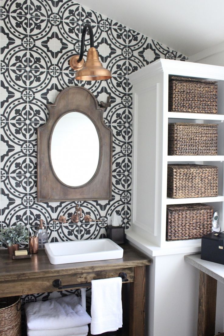 a bathroom with black and white wallpaper, wooden sink vanity and open shelving unit