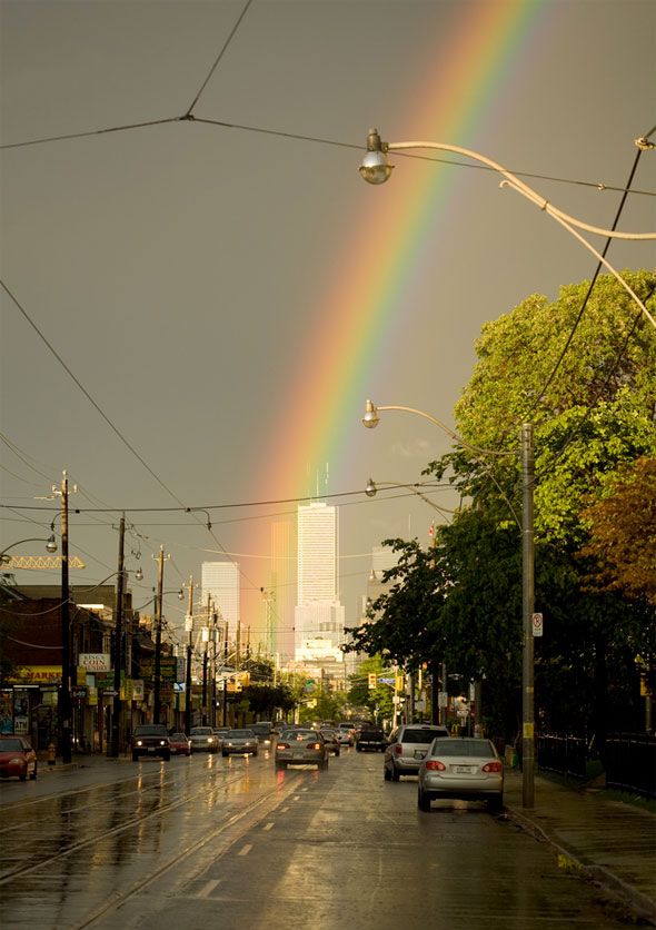 a rainbow in the sky over a city street