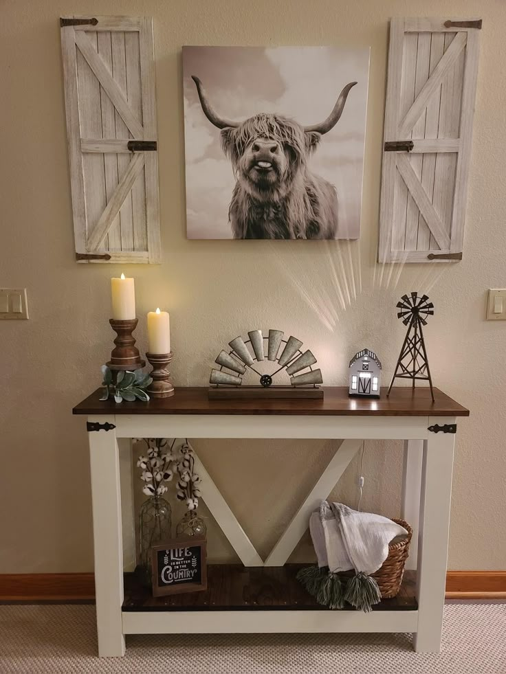 a table with some pictures on it and candles in front of the wall next to it