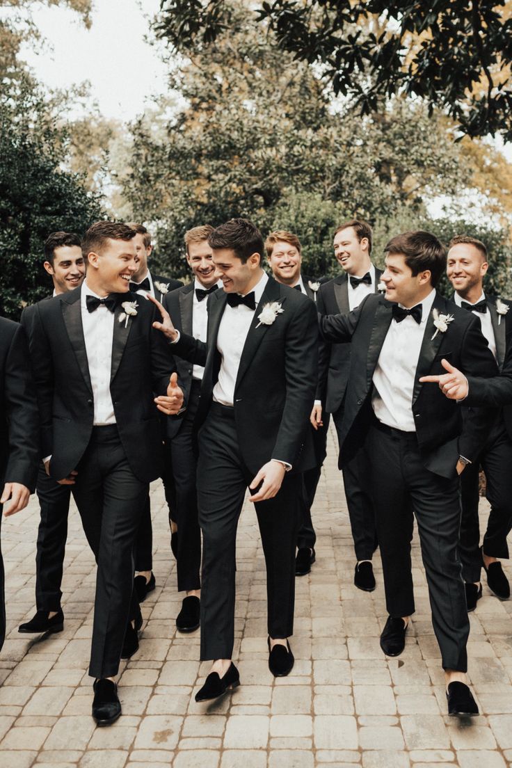 a group of men in tuxedos are walking together