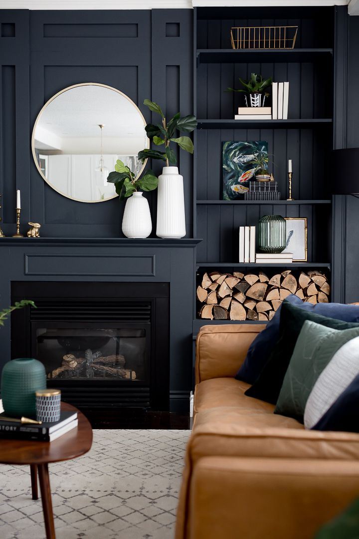 a living room filled with furniture and a fire place in front of a wall mounted mirror