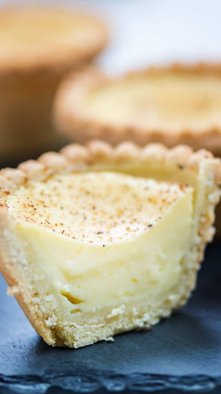 a piece of cheese pie sitting on top of a blue plate next to other pies