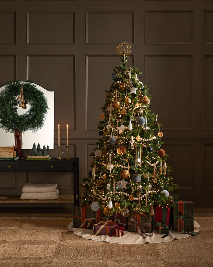 a decorated christmas tree in front of a mirror