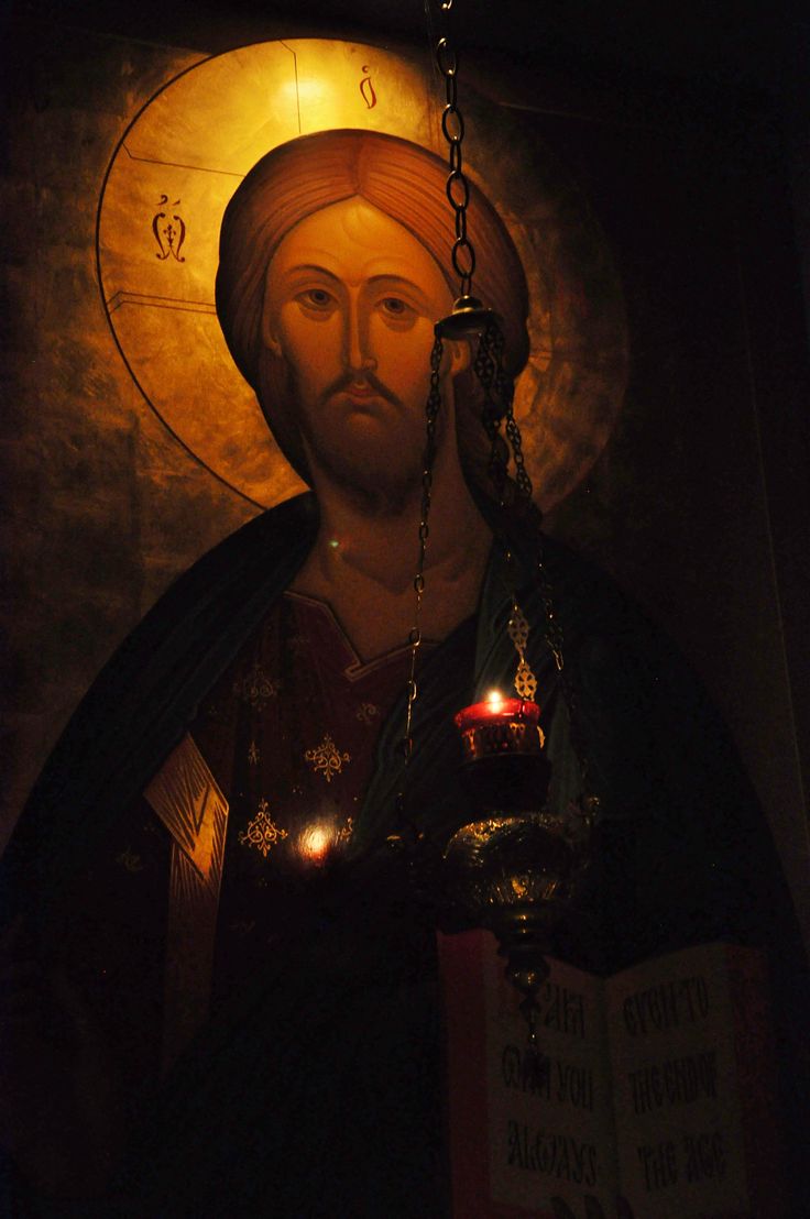 an image of jesus holding a candle in his right hand and wearing a chain around his neck