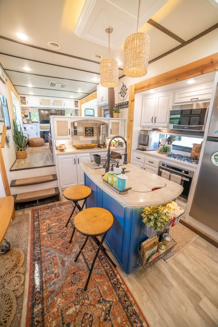 a kitchen with two stools next to an island in the middle of the room