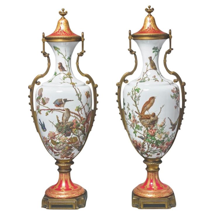 two vases with birds painted on them, one is gold and the other is white