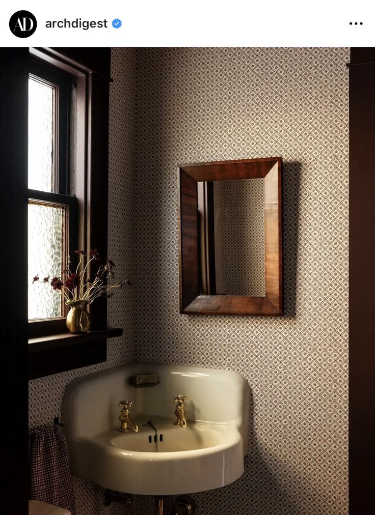 a bathroom sink sitting under a mirror next to a window