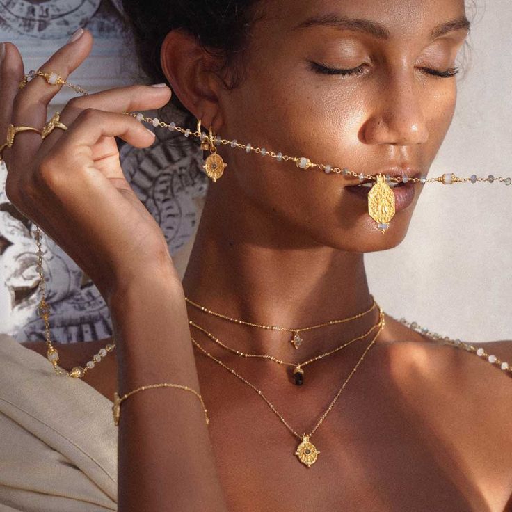 a woman wearing gold necklaces and jewelry