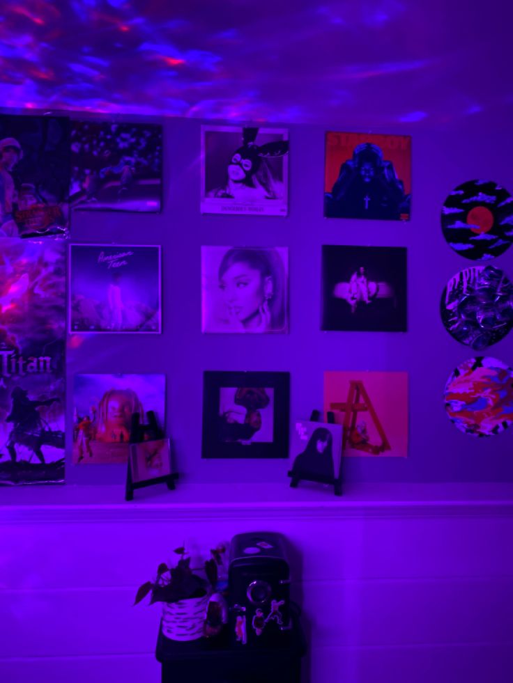 a room with purple lighting and pictures on the wall