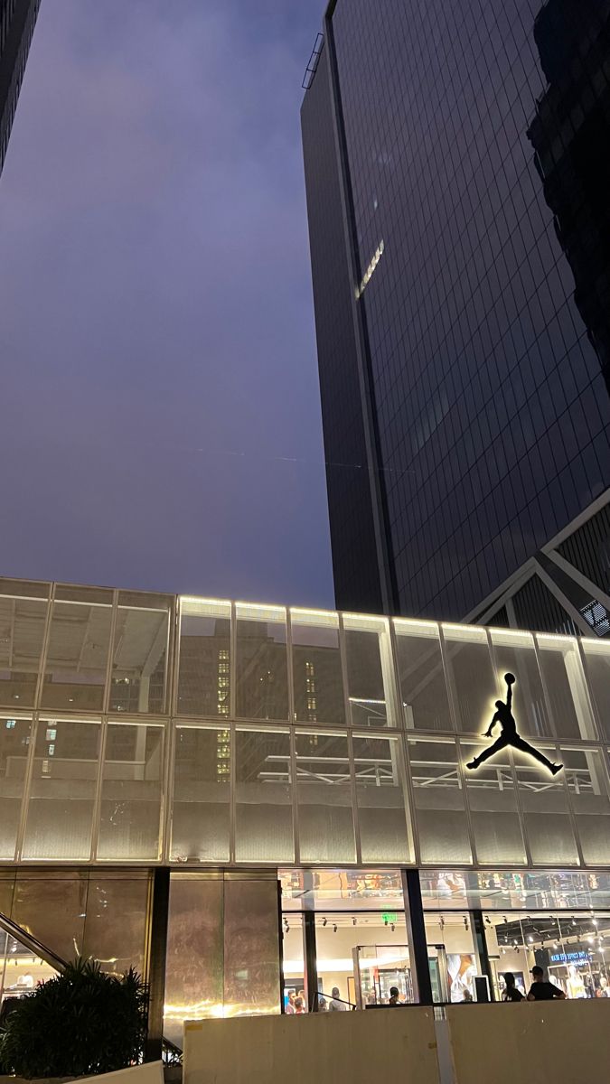 an image of a building that is lit up in the night time with people walking around it